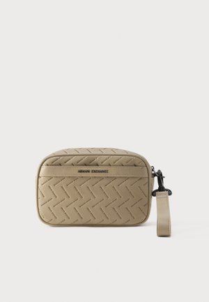 Bež zapestna torbica Armani Exchange z vzorcem vtisnjenega imena blagovne znamke, sprednjim žepom z zadrgo in odpravnim trakom na enobarvnem ozadju.
