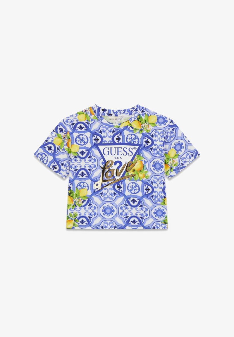 Haut court à manches courtes bleu et blanc avec motif de citrons jaunes et feuilles vertes, arborant un grand logo "GUESS" et le texte "Love" en or.