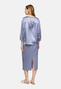Light purple satin dress with long, puffed sleeves and a back slit. The fabric has a smooth texture, and the design is fitted at the waist.