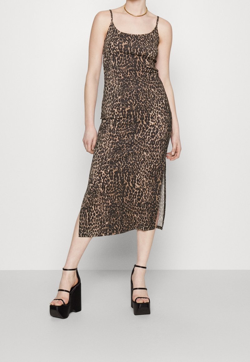 Robe midi à imprimé léopard avec fines bretelles spaghetti, dotée d'une fente latérale, fabriquée en matériau léger à texture lisse.