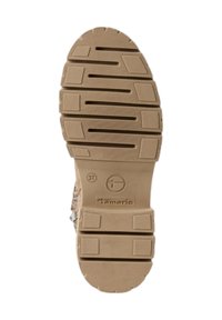 Semelle en caoutchouc tan avec des rainures et sections texturées. Présente un marquage de marque et de taille. Design robuste adapté à divers terrains.