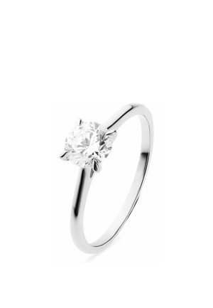 Silver solitaire ring with a round brilliant-cut diamond held by four prongs on a polished band against a white background.