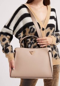 Sac à main structuré rose clair avec une finition texturée, logo doré et doubles poignées. Orné d'un bord noir et d'une bandoulière amovible.