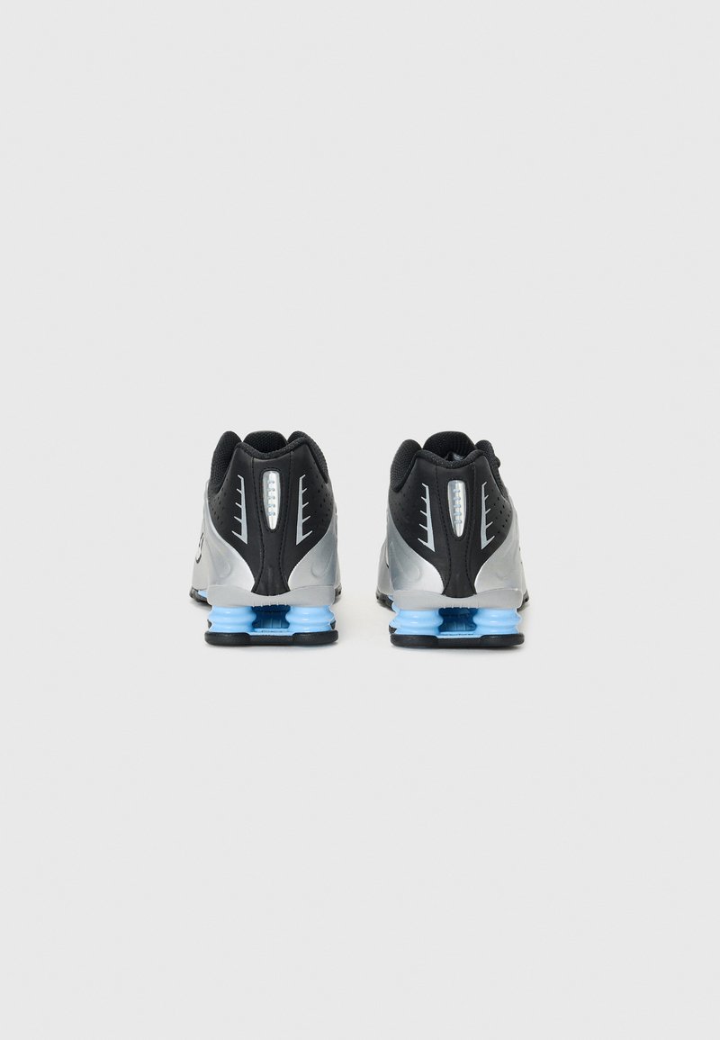 Zapatillas deportivas negras y plateadas con un diseño elegante, parte superior de malla con patrón, elementos de amortiguación azules y suelas de goma negras.