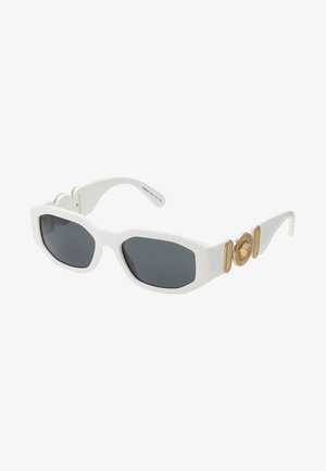 Óculos de sol brancos de plástico com lentes cinza-escuro, apresentando um detalhe emblema dourado e acabamentos texturizados nas hastes. Forma quadrada.