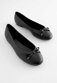 Schwarze Leder-Ballerinas mit runder Zehenpartie, einem kleinen Schleifenakzent an der Vorderseite und flacher Sohle. Glatte Textur und minimalistisches Design.