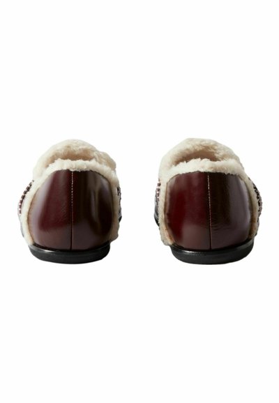 Pantofole in pelle bordeaux con rivestimento in pelliccia sintetica, tallone arrotondato, suola piatta e cuciture decorative lungo i lati.