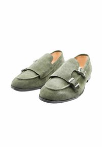 Mocassini in suede verde con punta arrotondata, doppia fibbia sulla parte superiore, soletta a contrasto color tan e suola in gomma nera.