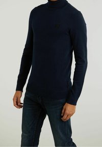 Marinblå turtleneck-tröja i strukturerad stickning med slim fit, som har ett litet svart logotypmärke på bröstet samt ribbad mudd och nederkant.