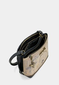 Bolso de cuero con un frente en tono marrón claro que presenta un estampado de paisaje urbano, parte trasera negra, múltiples compartimentos con cremallera y un detalle de encanto en forma de corazón.