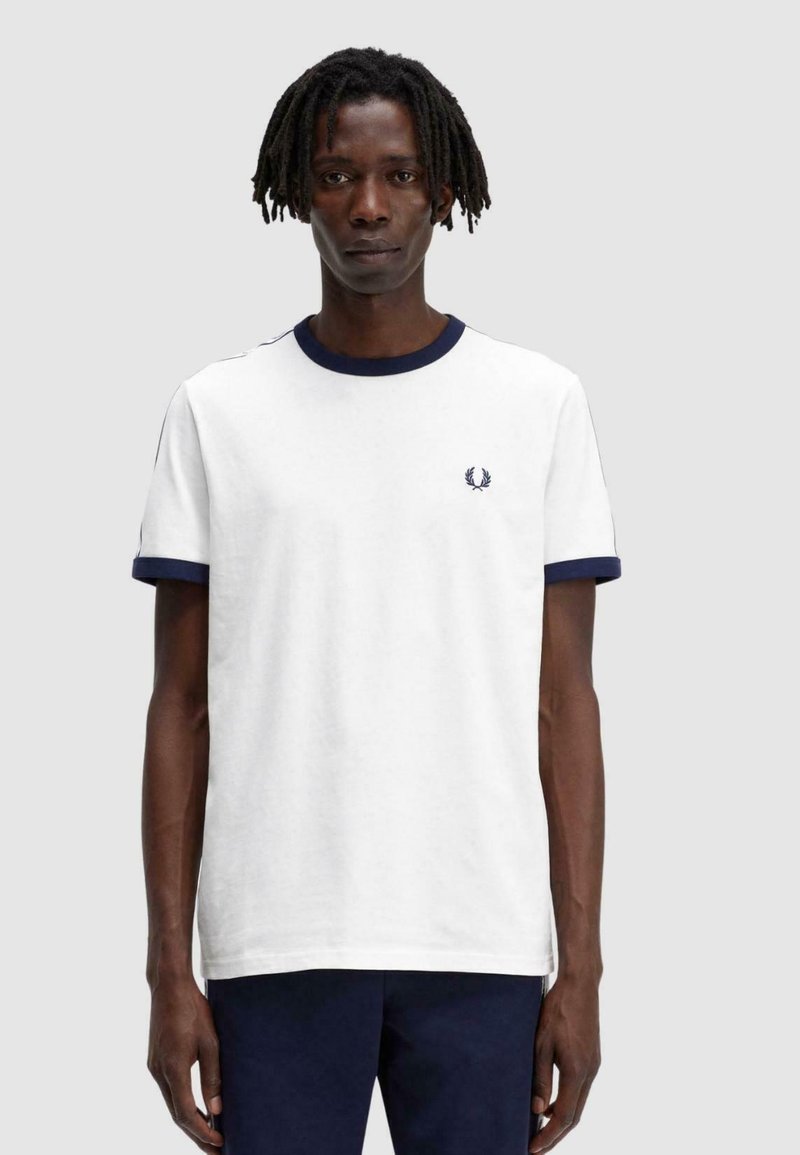 Camiseta blanca con cuello y puños de manga de canalé en azul marino. Presenta un pequeño logo bordado en el pecho. Material de algodón, cuello redondo.