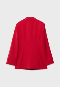 Rdeč, po meri krojen blazer z ovratnikom reverjem, dolgimi rokavi in gladko teksturo. Ima čist kroj brez vidnih delov kovinske opreme.