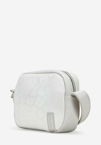 Bolso de cuero blanco con un acabado liso y una sutil textura, que presenta un cierre con cremallera, un asa lateral y un acento de logo.