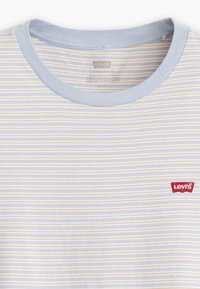 Ljusblå och vit randig T-shirt med gula ränder, ribbad krage och en liten röd Levi's-logotyp på vänster bröst.