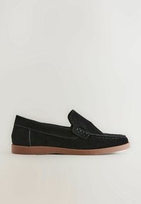 Mocassin en daim noir avec surpiqûres et semelle en caoutchouc marron, présenté de profil sur un fond clair uni.