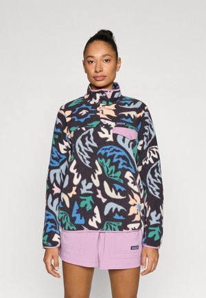 Fliisist pullover kõrge kraega, tume taust, millel on värvilised lehemustrid rohelises, sinises, roosas ja kreemjas. Sisaldab lilla rinnataskut.