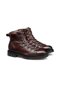 Bottines de randonnée en cuir marron avec une semelle robuste, à lacets et accents en métal. Dotées de coutures renforcées et d'un col rembourré.