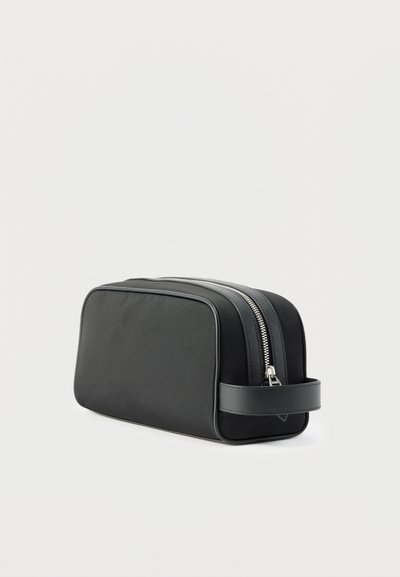 Μαύρο ορθογώνιο νεσεσέρ με διπλό ασημί φερμουάρ και δερμάτινη πλαϊνή λαβή, εμφανίζεται σε λευκό φόντο.