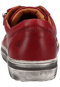 Rode leren sneaker met een gladde afwerking, witte stiksels en een licht versleten zwarte rubberen zool. Het interieur heeft een tan kleurige stoffen voering.