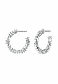 Pendientes de aro de plata con un diseño texturizado y ondulado. Cada pendiente cuenta con un cierre de tornillo. Acabado suave y brillante en toda su superficie.