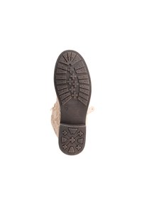 Suola della scarpa con una superficie in gomma nera texturizzata, caratterizzata da un motivo di forme che migliorano la presa e un design superiore in crochet beige.