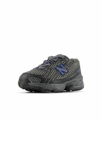 Black and gray athletic shoe featuring mesh fabric, prominent logo, textured sole, and reflective accents. Curved design with lace-up closure.