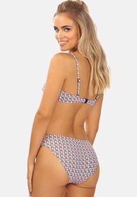 Zestaw bikini w kolorowy geometryczny wzór. Wykonany z elastycznego materiału, posiada cienkie regulowane ramiączka i zapięcie na plecach dla bezpiecznego dopasowania.