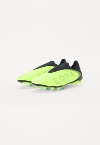 Neon gul fodboldstøvler med en struktureret overdel, sorte accenter, slip-on design og multicolor knopper til trækkraft. "COPA" logoet er fremhævet.