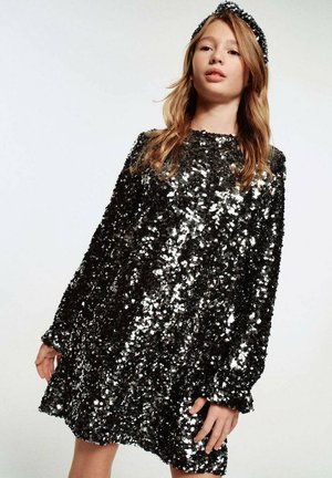 Schwarzes Paillettenkleid mit langen Ärmeln, lockerem Schnitt und rundem Ausschnitt, verziert mit glänzenden silbernen Pailletten, die einen schimmernden Effekt erzeugen.