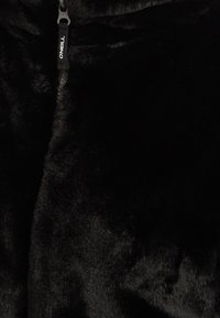 Zwarte fleece jas met een getextureerde, zachte oppervlakte. Voorzien van een rits aan de voorkant met een merkpulltab, gemaakt van synthetische materialen.