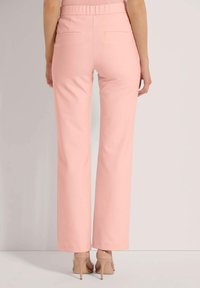 Lichtroze, hooggepolsterde broeken met een rechte pijpdesign, voorzien van achterzakken en een gladde stof. Draag met naaldhakken in huidskleur.