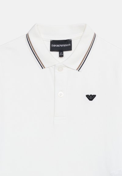 Polo blanc avec patte à deux boutons, col rayé et logo Emporio Armani brodé en noir sur la poitrine.