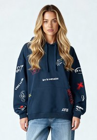 Felpa blu navy con tasca anteriore, cappuccio con cordino e varie grafiche colorate, tra cui testo, simboli e motivi sulle maniche.