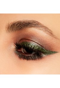 Gros plan sur un œil avec un eyeliner vert audacieux et un fard à paupières scintillant dans des tons de marron et d'or. De longues cils noirs entourent l'œil.