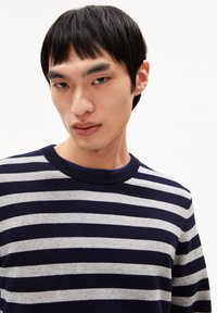 Gestreifter Pullover in Marineblau und Grau mit Rundhalsausschnitt, aus einem weichen, gestrickten Stoff, der horizontale Streifen in unterschiedlichen Breiten aufweist.