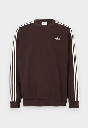 Tmavě hnědá mikina Adidas s bílými třemi pruhy podél rukávů a bílým logem Adidas trefoil na hrudi.