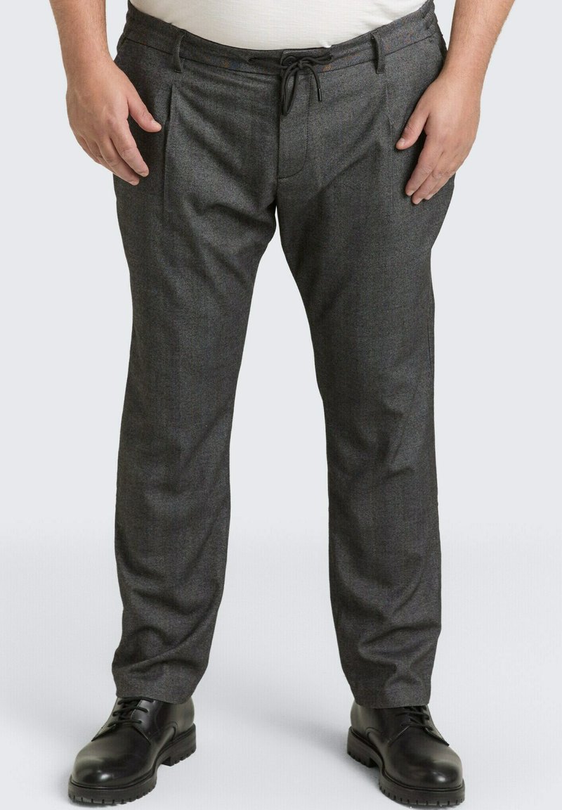 Man wearing dark gray straight-fit pants with a drawstring waist and black leather lace-up shoes on a light background.