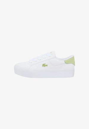 Sneaker bianca bassa con suola spessa, lacci bianchi, logo di coccodrillo verde sul lato e linguetta del tallone verde con il marchio "Lacoste".