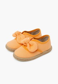 Scarpe in tela arancione con un accent sulla parte anteriore in nodo di tessuto, tomaia testurizzata e suola in stile paglia intrecciata. Design classico senza lacci.