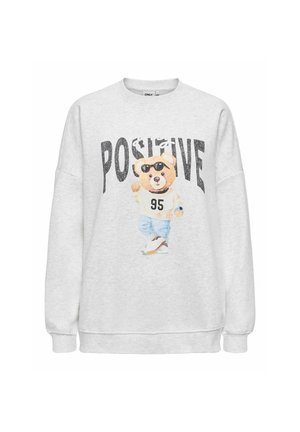 Sweat-shirt gris clair avec un ours en peluche portant des lunettes de soleil, un pull blanc marqué 95, un pantalon bleu, et le mot "POSITIVE" en grandes lettres noires au-dessus.