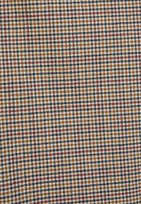 Geweven stof met een meerkleurig ruitpatroon met bruin, marineblauw, rood en witte vierkanten. Gladde textuur met gelijkmatige stitching.