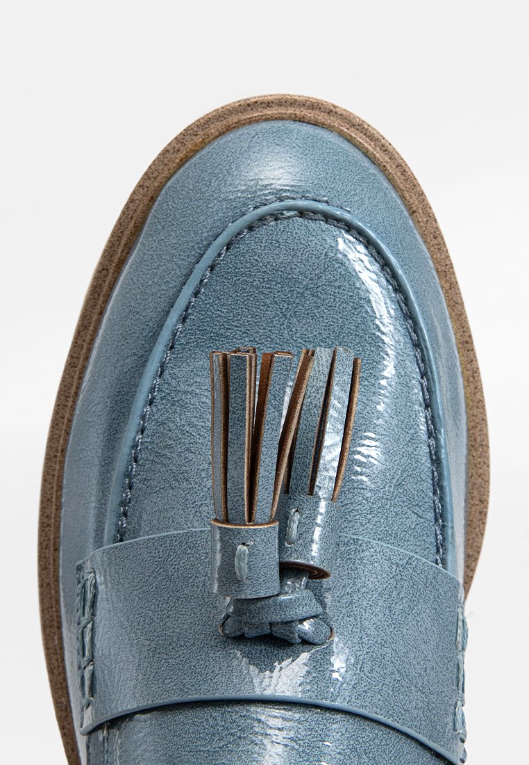 Helleblaue Lederloafer mit glänzender Oberfläche, dekorativem Quasten-Detail und strukturiertem Sohlen, versehen mit kontrastierenden braunen Akzenten.