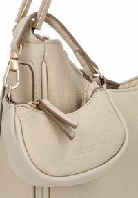 Beige Lederhandtasche mit strukturierten Oberflächen und einer kleinen abnehmbaren Tasche. Sie verfügt über goldene Beschläge und doppelte Trageriemen.