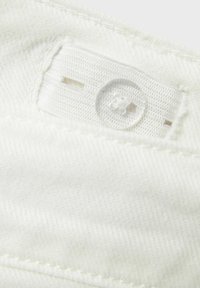 Tessuto bianco con chiusura a bottone, dettagli cuciti e una trama testurizzata, che mette in evidenza la superficie liscia e morbida del materiale.