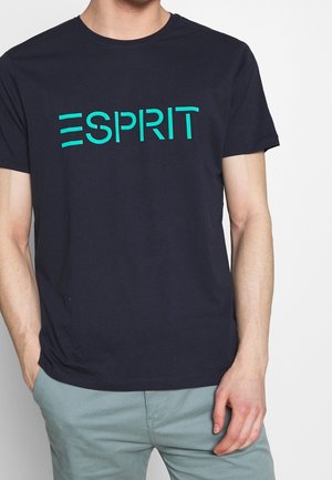T-shirt en coton bleu marine avec un logo "ESPRIT" turquoise audacieux sur la poitrine. Manches courtes et col rond.