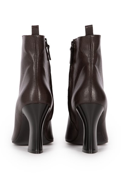 Brown textured leather ankle boots with a high glossy black heel, featuring a zipper closure and a pull tab at the back.