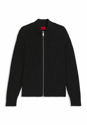 Cardigan zip-up a costine nere con colletto alto, maniche lunghe e un'etichetta rossa all'interno del colletto.