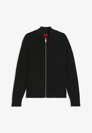 Gilet zippé côtelé noir avec un col montant, des manches longues et une étiquette rouge à l'intérieur de l'encolure.