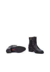 Botines de cuero negro hasta el tobillo con cremallera lateral, punta cuadrada y un tacón bajo apilado; suela texturizada para agarre.