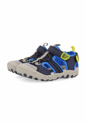 Zapatos de agua azules y marinos con acentos grises, material de malla, correa de velcro y suela de goma texturizada con tracciones distintivas.